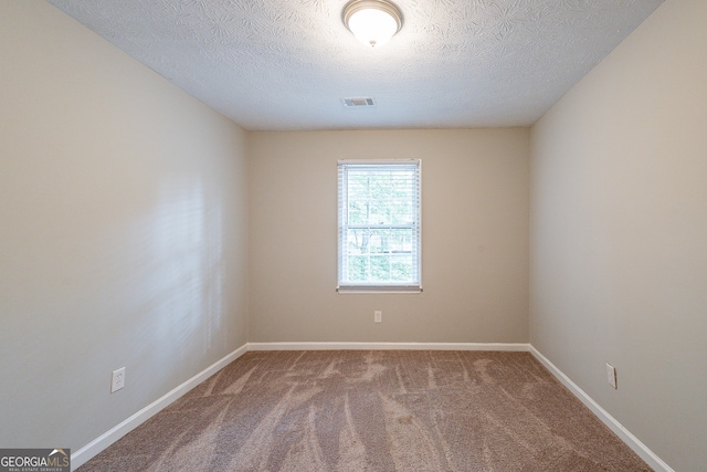 carpeted spare room with a textured ceiling