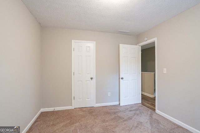 unfurnished bedroom with carpet flooring and a textured ceiling