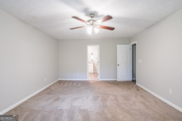 unfurnished bedroom featuring light carpet, ensuite bath, a textured ceiling, and ceiling fan