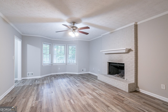 unfurnished living room with a brick fireplace, a textured ceiling, and light hardwood / wood-style flooring