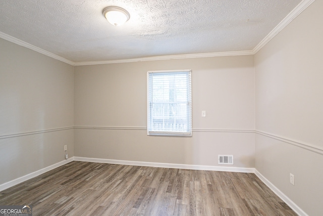 spare room featuring ornamental molding, a textured ceiling, and hardwood / wood-style floors