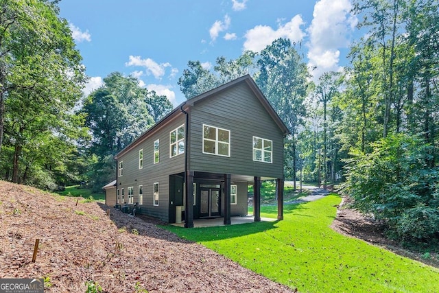 view of side of property featuring a yard and a patio area