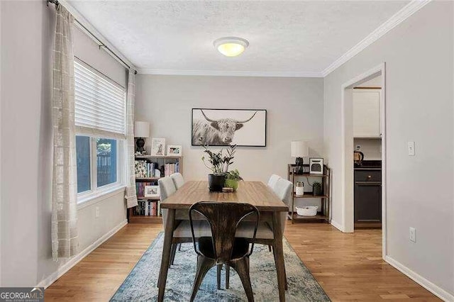 dining area featuring light hardwood / wood-style floors and ornamental molding