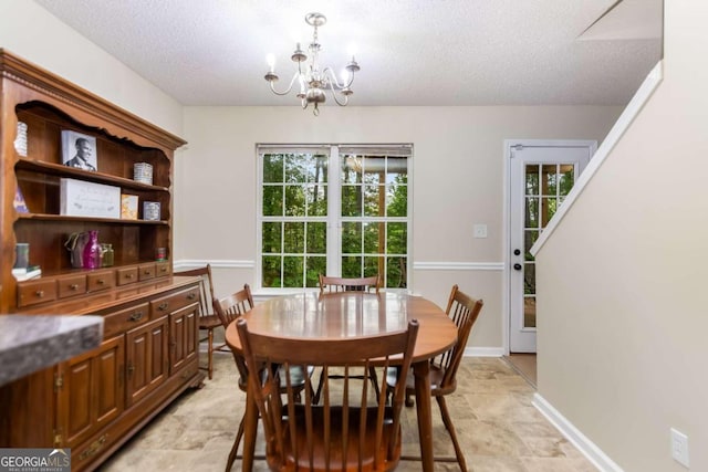 dining area with a textured ceiling and a chandelier