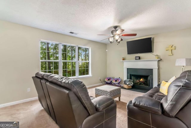 carpeted living room with ceiling fan and a textured ceiling