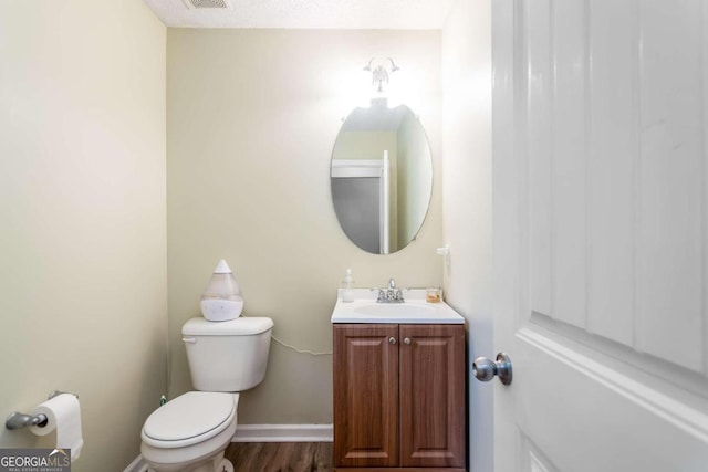 bathroom with hardwood / wood-style flooring, vanity, and toilet