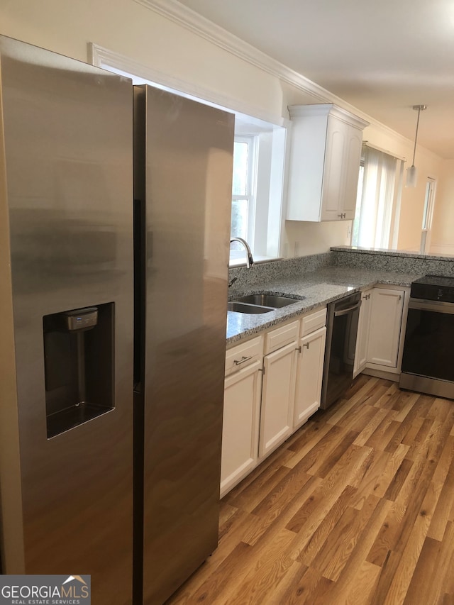 kitchen featuring light stone countertops, stainless steel appliances, sink, white cabinetry, and light hardwood / wood-style flooring