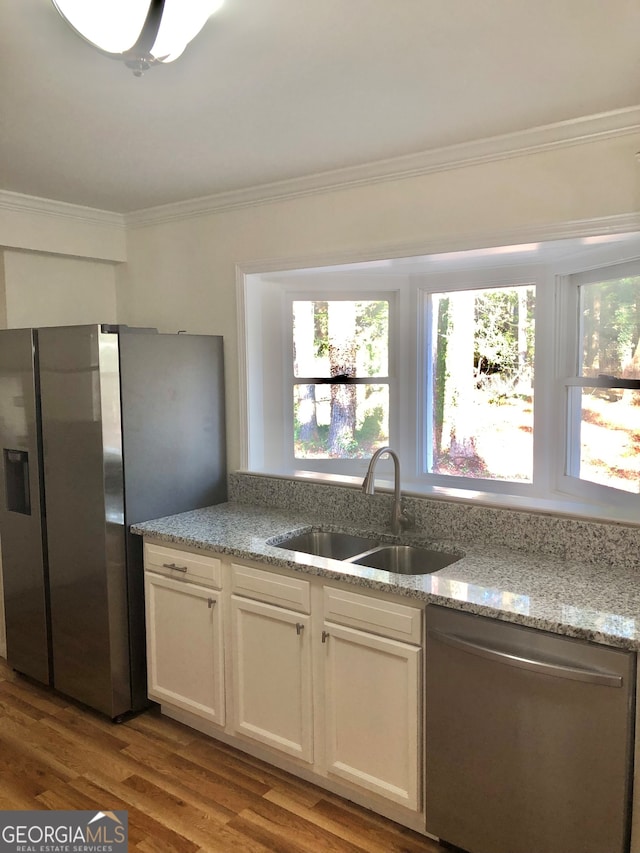 kitchen featuring light hardwood / wood-style floors, sink, stainless steel appliances, light stone countertops, and white cabinetry