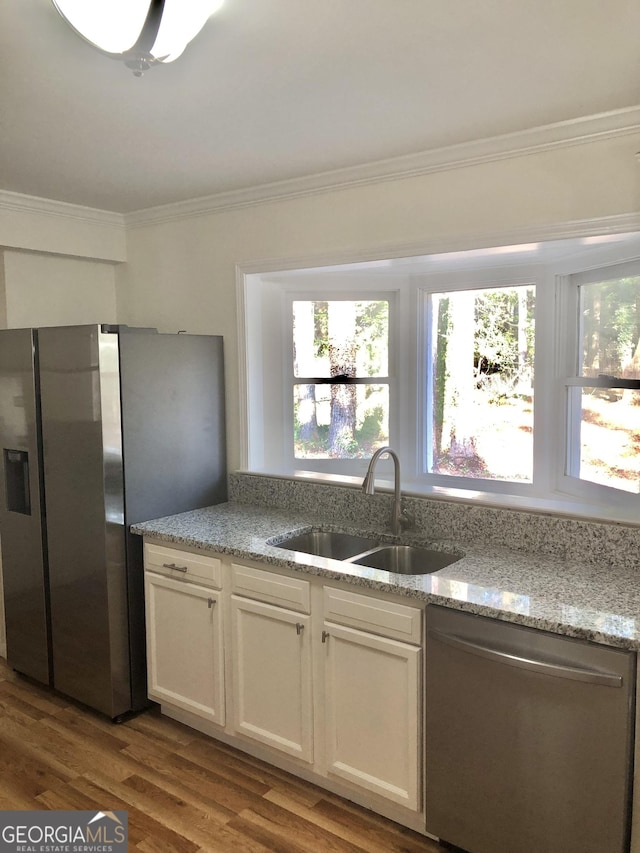 4330 Cedar Valley Ln, Conley, GA 30288 - kitchen with appliances with stainless steel finishes, crown molding, light stone counters, wood finished floors, and white cabinetry