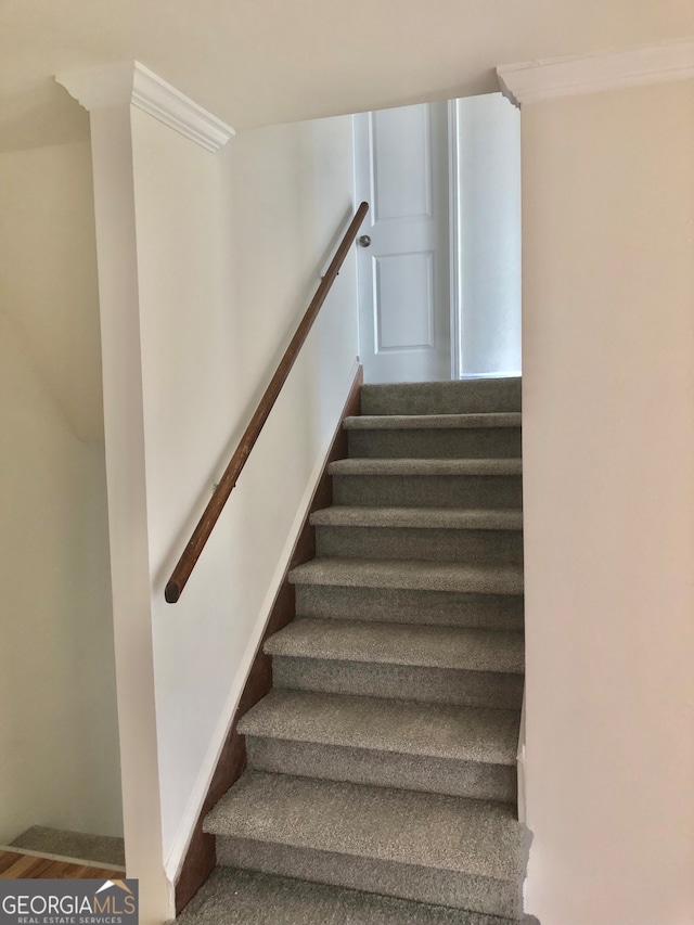 stairway featuring ornamental molding