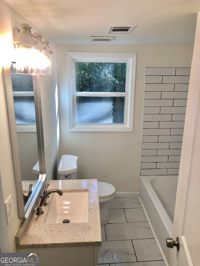 full bathroom featuring washtub / shower combination, vanity, and toilet