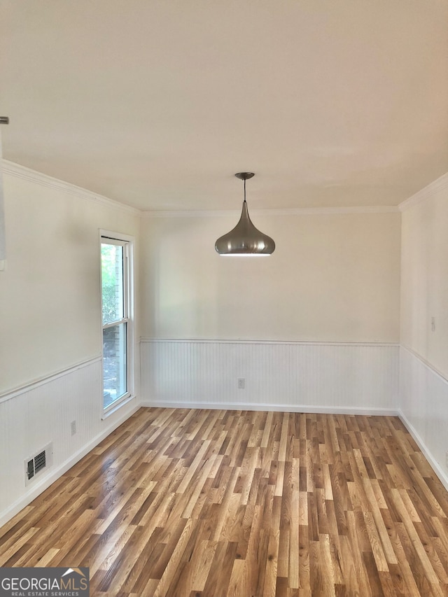 empty room with crown molding and hardwood / wood-style floors