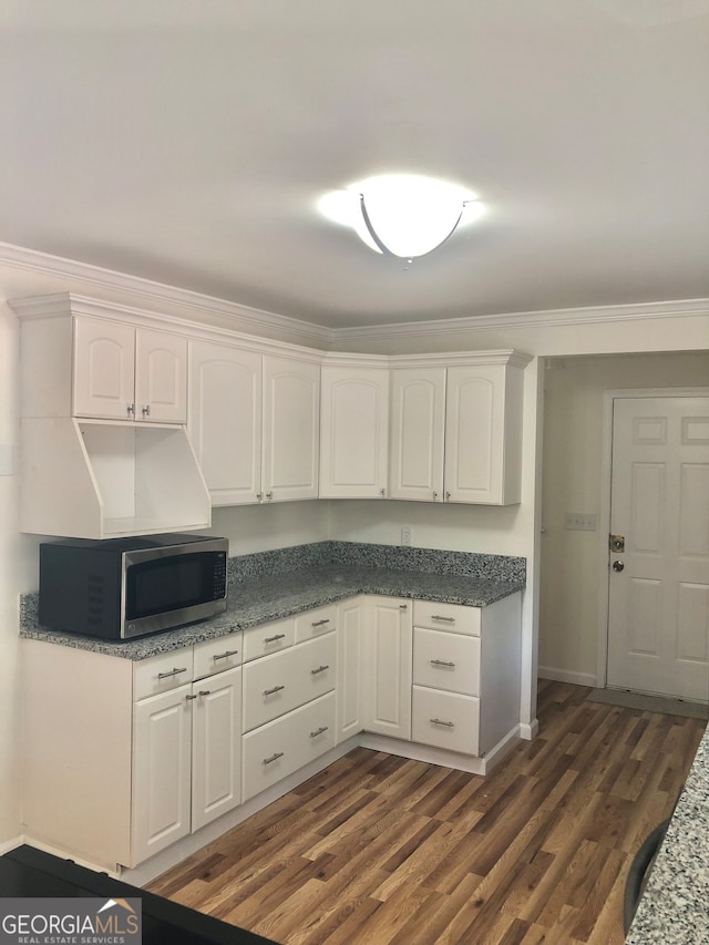 kitchen with ornamental molding, dark hardwood / wood-style flooring, and white cabinets