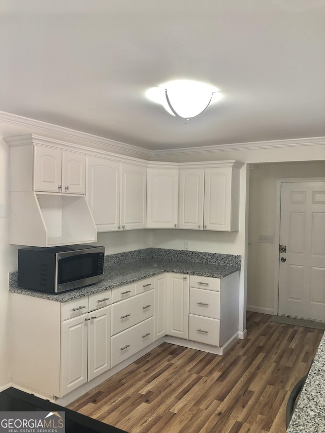 4330 Cedar Valley Ln, Conley, GA 30288 - kitchen with stainless steel microwave, white cabinets, ornamental molding, and dark wood-style floors