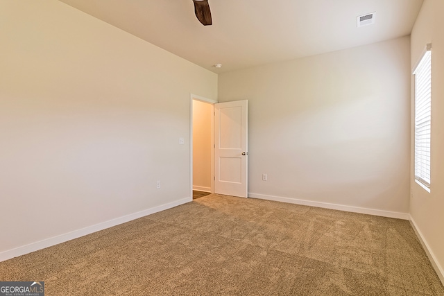 carpeted spare room with ceiling fan