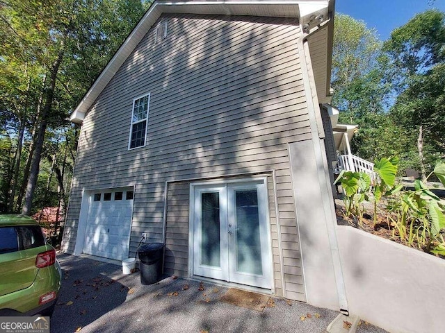 view of property exterior with french doors and a garage