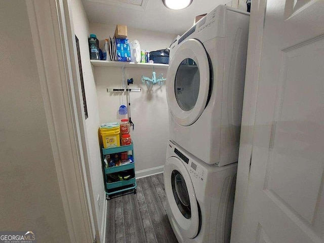 laundry area featuring stacked washer and dryer and dark hardwood / wood-style flooring