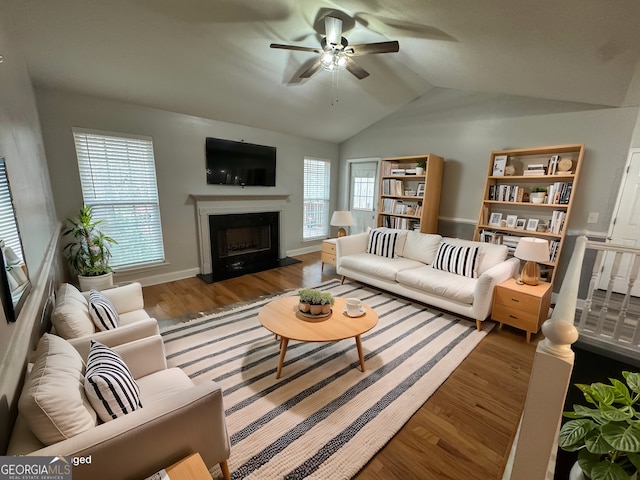 living room featuring hardwood / wood-style flooring, vaulted ceiling, and ceiling fan