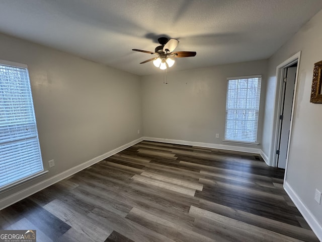 empty room with dark hardwood / wood-style flooring, ceiling fan, and a textured ceiling