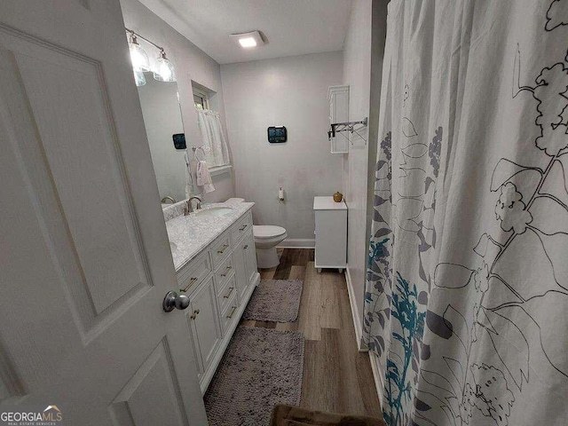 bathroom featuring vanity, hardwood / wood-style floors, and toilet