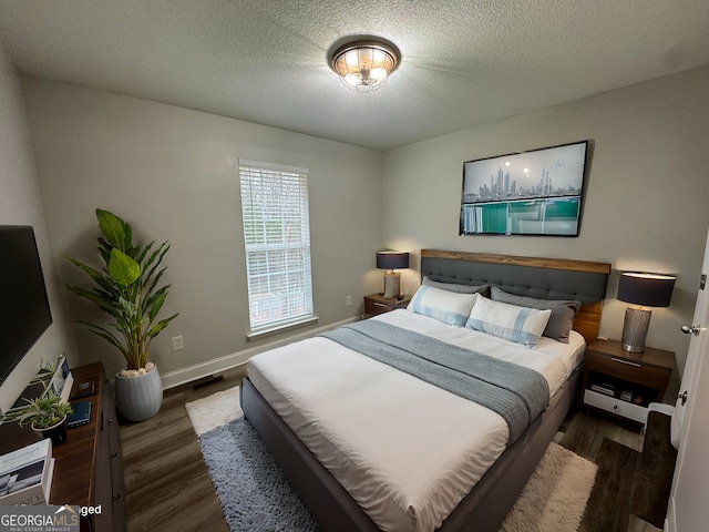 bedroom with dark wood-type flooring and a textured ceiling