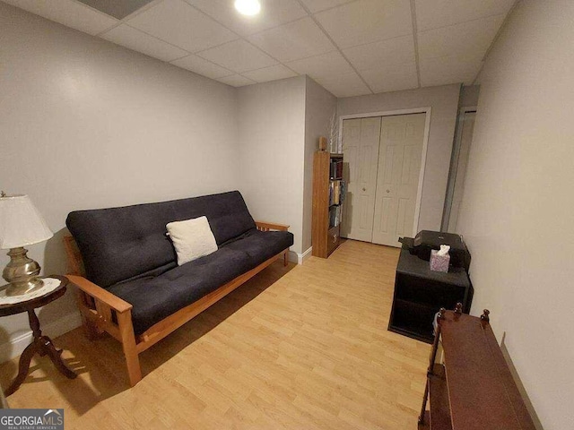 living room with hardwood / wood-style flooring and a drop ceiling