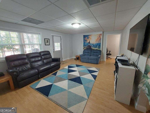 living room with light wood-type flooring and a drop ceiling