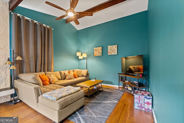 living room with ceiling fan, hardwood / wood-style floors, and vaulted ceiling with beams