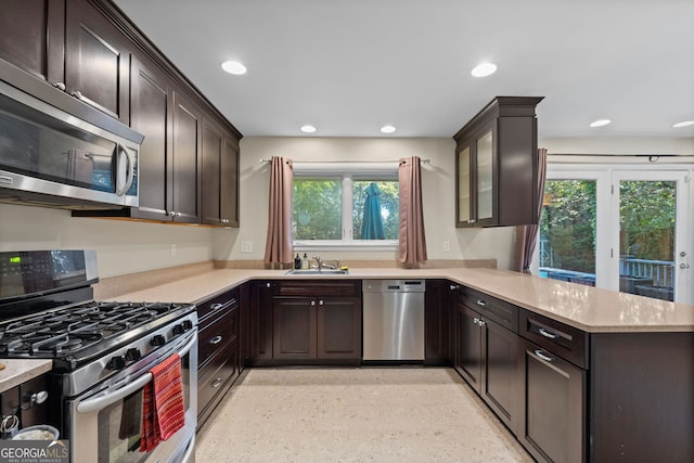 kitchen with sink, stainless steel appliances, kitchen peninsula, and plenty of natural light