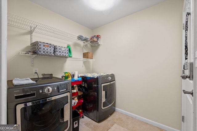 laundry area with light tile patterned flooring and washing machine and clothes dryer