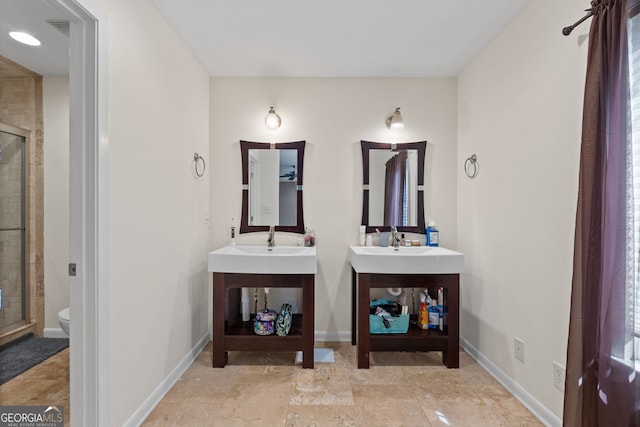 bathroom with a shower with door, vanity, and toilet