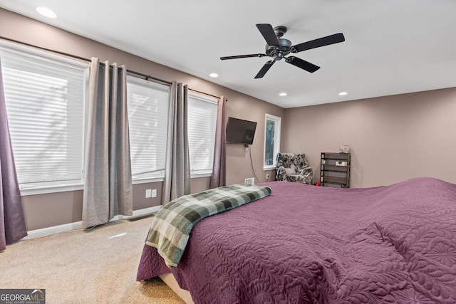 bedroom featuring multiple windows, light carpet, and ceiling fan