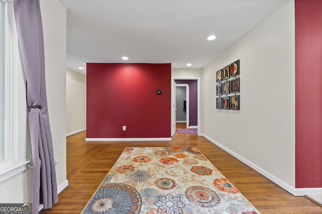 corridor with hardwood / wood-style flooring