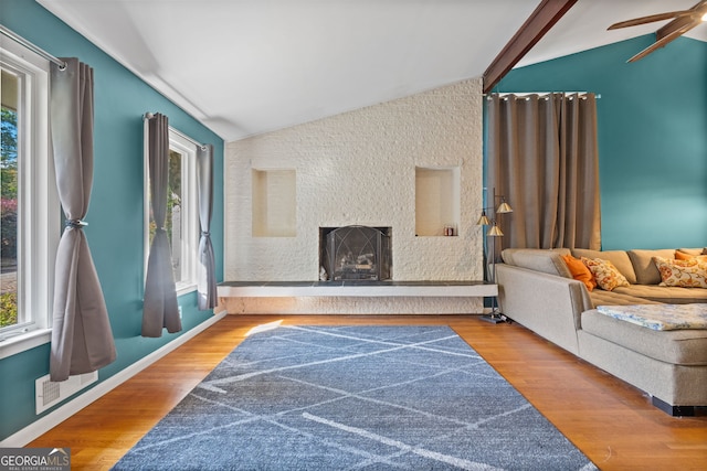 living room with lofted ceiling, a fireplace, ceiling fan, and wood-type flooring