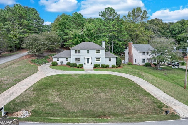 colonial inspired home featuring a front lawn