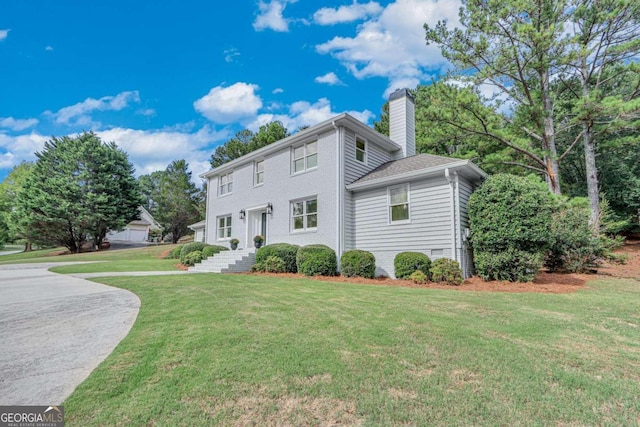 view of front of property with a garage and a front lawn