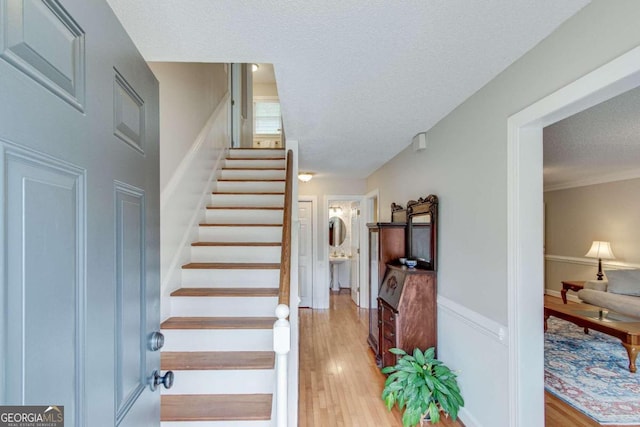 stairway with hardwood / wood-style flooring and a textured ceiling