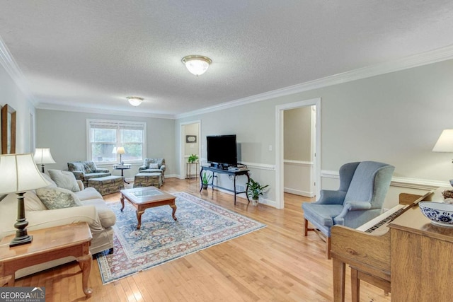 living room featuring wood-type flooring, a textured ceiling, and ornamental molding