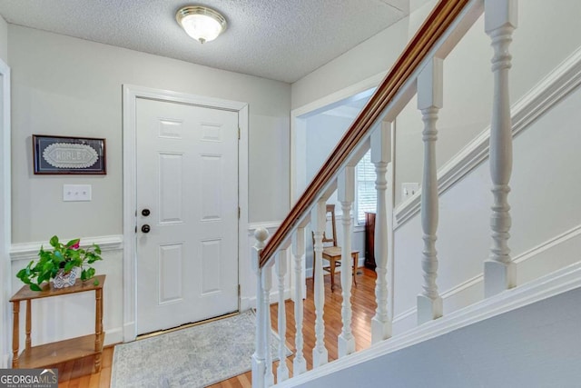 foyer entrance with hardwood / wood-style flooring and a textured ceiling