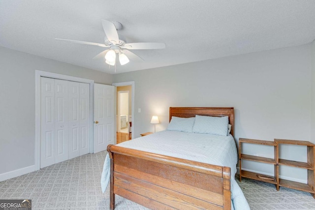 carpeted bedroom with ceiling fan, a closet, and a textured ceiling