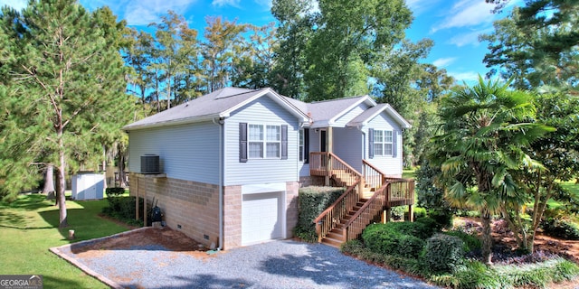 view of front of property featuring central AC unit, a garage, and a front yard