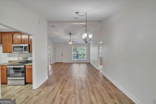 kitchen featuring ceiling fan with notable chandelier, brown cabinets, light wood finished floors, light countertops, and appliances with stainless steel finishes