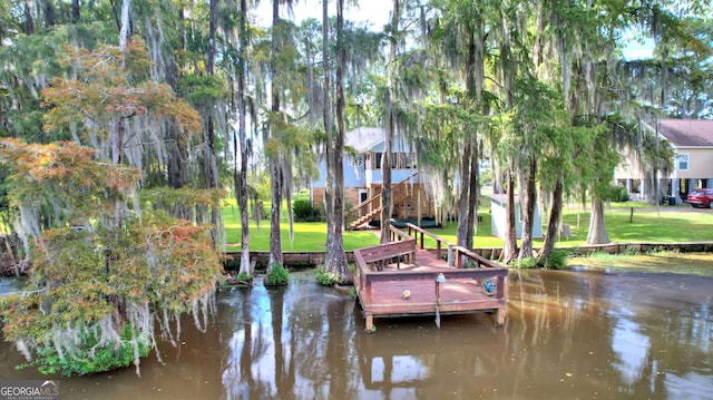 view of dock featuring a yard and a water view