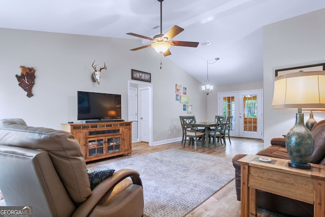 living room featuring ceiling fan with notable chandelier, high vaulted ceiling, french doors, and light hardwood / wood-style flooring