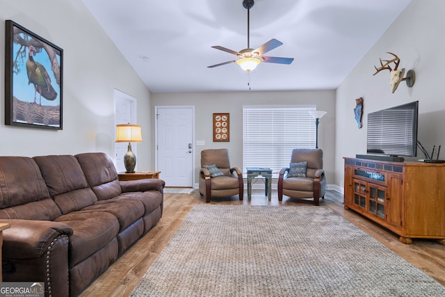 living room with light wood-type flooring, ceiling fan, and vaulted ceiling