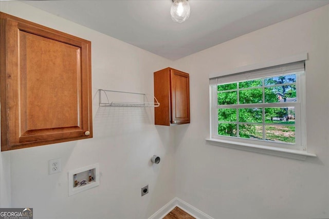 clothes washing area featuring baseboards, washer hookup, hookup for an electric dryer, and cabinet space