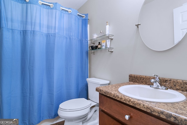 bathroom featuring a shower with shower curtain, vanity, and toilet