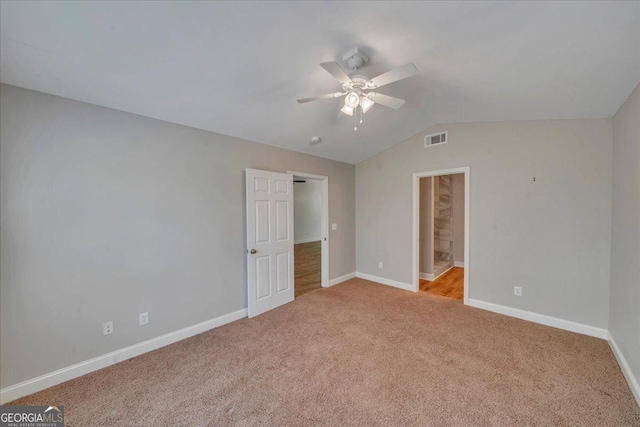 unfurnished bedroom with vaulted ceiling, carpet flooring, visible vents, and baseboards