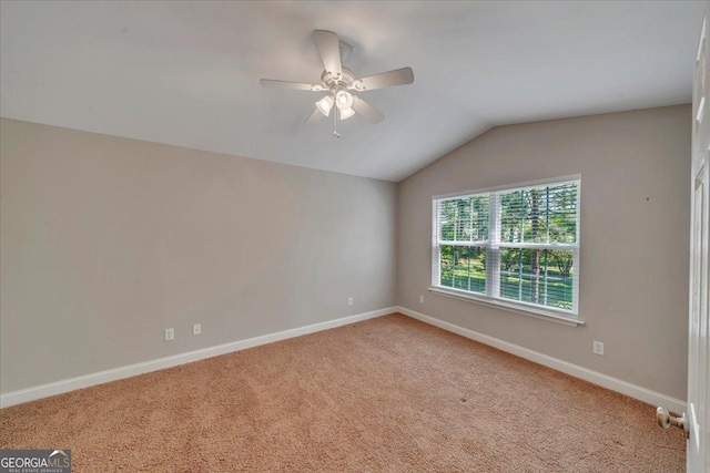 spare room with lofted ceiling, a ceiling fan, carpet flooring, and baseboards