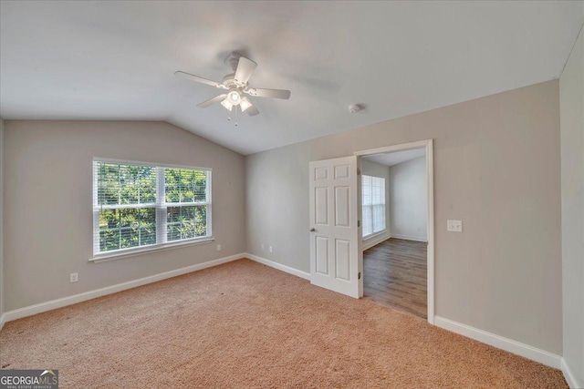 carpeted spare room with lofted ceiling, baseboards, and ceiling fan